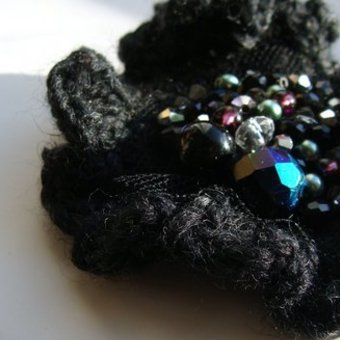 "small, knitted brooch"